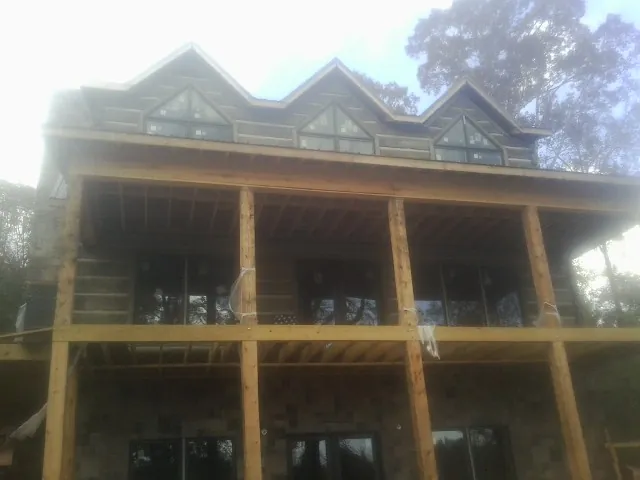 Dormers and porch framing on a large log home under construction — Roof Coating work by our crew in Killeen