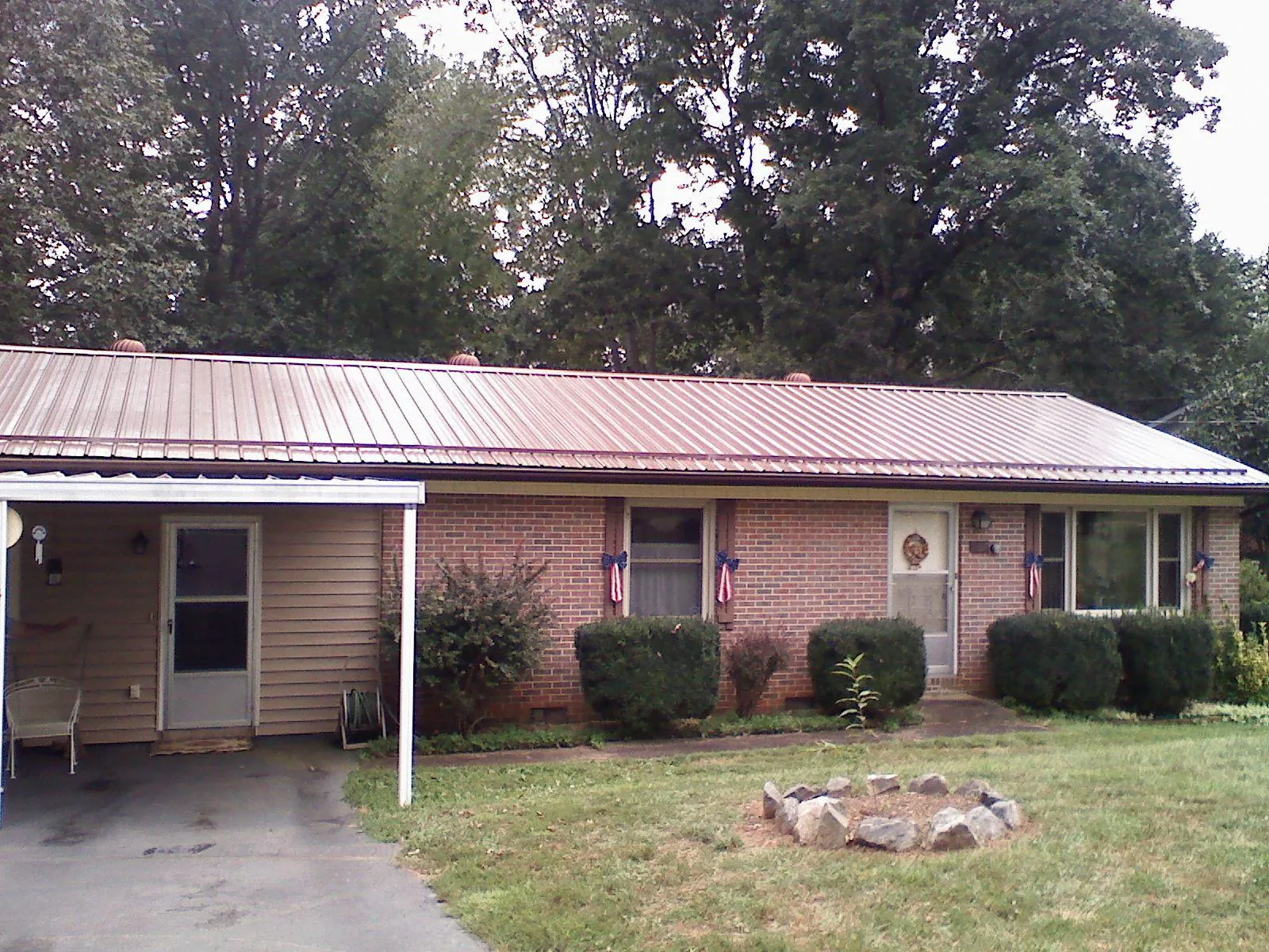 Bronze metal roof and carport on a brick ranch home — Roof Repair work by our crew in Killeen