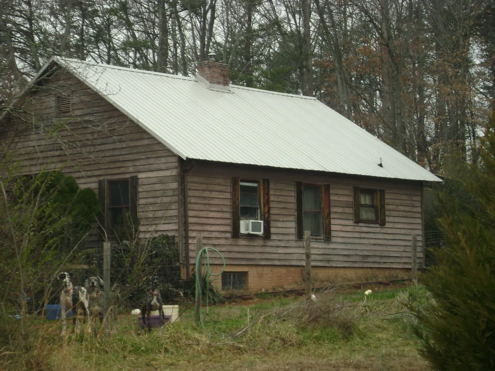 White metal roof on an old wood sided farmhouse, from a Metal Roof Installation job in Killeen